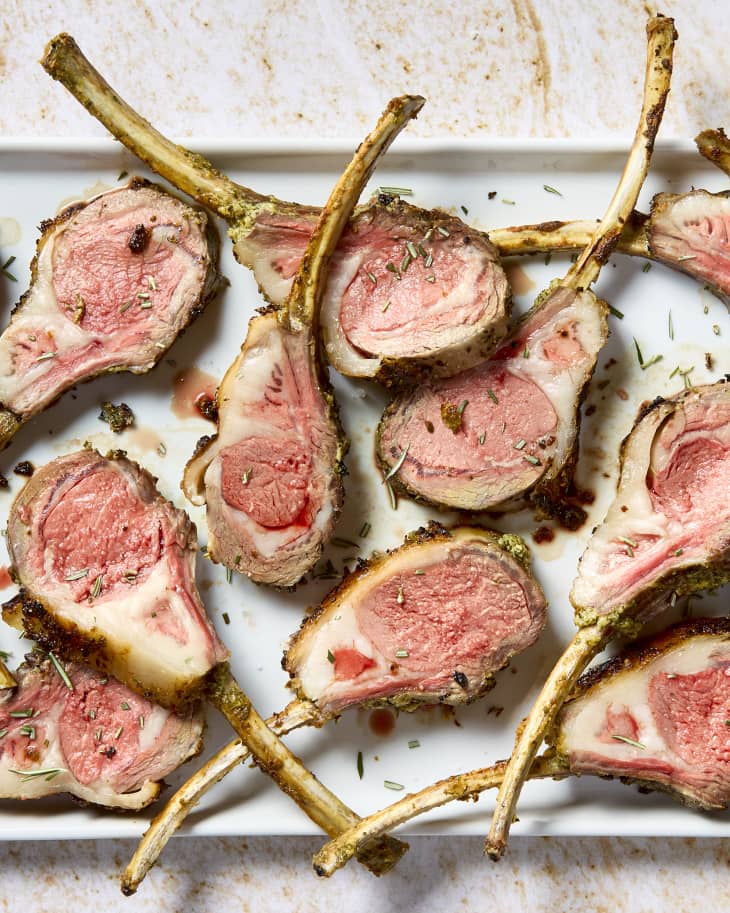 overhead shot of cut pieces of lamb on a white platter.